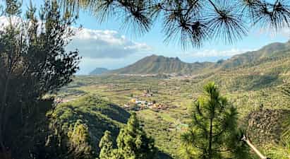 Utsikt over et grønt dalområde med landsbyer og fjell i bakgrunnen. (AI-generert tekst)
