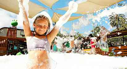 En gruppe mennesker nyter en skummende aktivitet under et skjermtak utendørs. (AI-generert tekst)