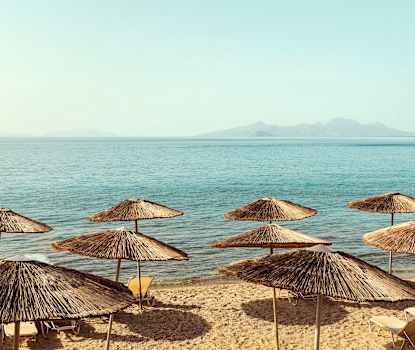 Stranden nedenfor hotellet. Solsengene byttes ut sommeren 2025 og ser derfor annerledes ut enn på bildet