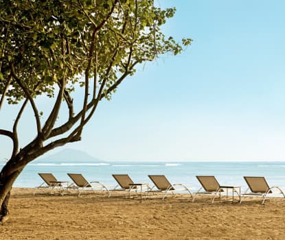 På stranden nedenfor hotellet er det gratis solsenger for hotellets gjester