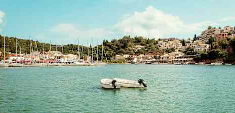 To små motorbåter på vannet med en havn og bygninger i bakgrunnen. (AI-generert tekst)