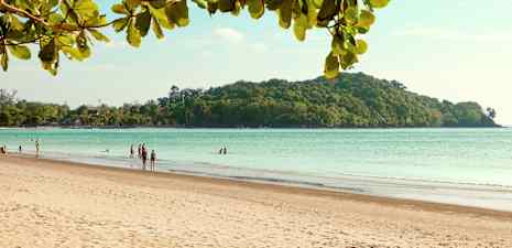 En sandstrand med mennesker, havet og en skogkledd øy i bakgrunnen. (AI-generert tekst)