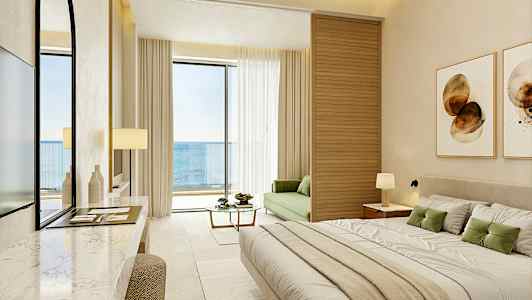 Et moderne hotellrom med havutsikt, møblert med en stor seng, en grønn sofa og en balkong. (AI-generert tekst)