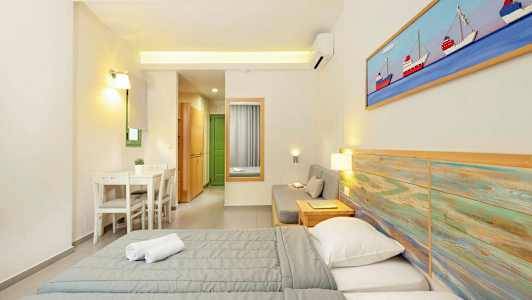 Et hotellrom med to senger, en sittegruppe og en liten spiseplass. (AI-generert tekst)