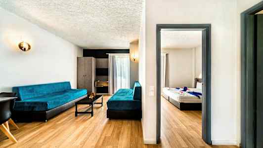 Et hotellrom med en stue og et soverom. (AI-generert tekst)