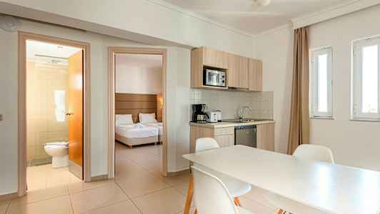 Et rom med kjøkken og spisebord, soverom og bad. (AI-generert tekst)