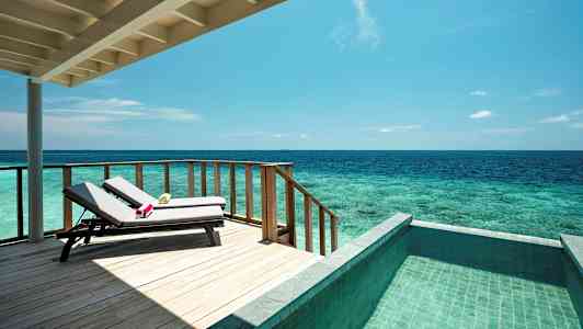 En terrasse med solsenger, havsutsikt og et basseng. (AI-generert tekst)