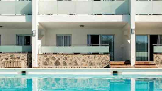 Utvendig bygning med basseng foran. (AI-generert tekst)