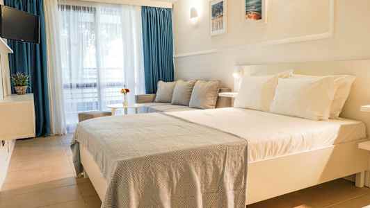 Et hotellrom med en stor seng, sofa og bord. (AI-generert tekst)