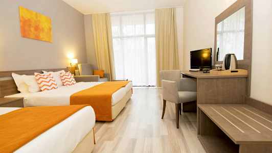 Et hotellrom med to senger, en skrivebordskrok og sittemøbler. (AI-generert tekst)