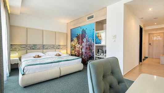 Bilde av et hotellrom med en dobbeltseng, havsinspirert dekor bak sengen og skrivebord med stol. (AI-generert tekst)