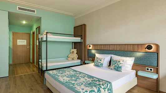 Et hotellrom med en dobbeltseng og en køyeseng, innredet i turkise og beige farger. (AI-generert tekst)