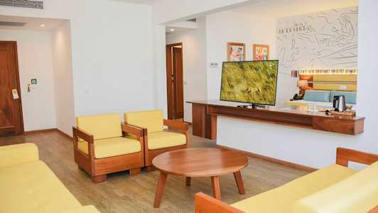 Et hotellrom med sittegruppe og en TV. (AI-generert tekst)