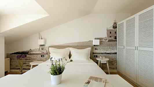 Soverom med en dekorativ vegg med motiv av hav og bygninger. (AI-generert tekst)