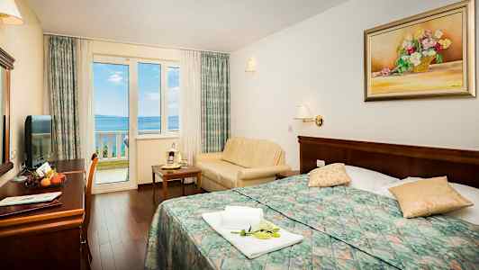 Bilde av hotellrom med utsikt mot havet gjennom et vindu. (AI-generert tekst)