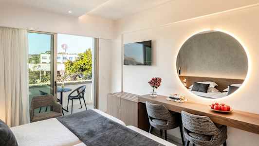 Moderne hotellrom med seng, speil, skrivebord, stoler og balkong. (AI-generert tekst)