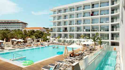 Et hotell med et svømmebasseng omgitt av solsenger og parasoller. (AI-generert tekst)