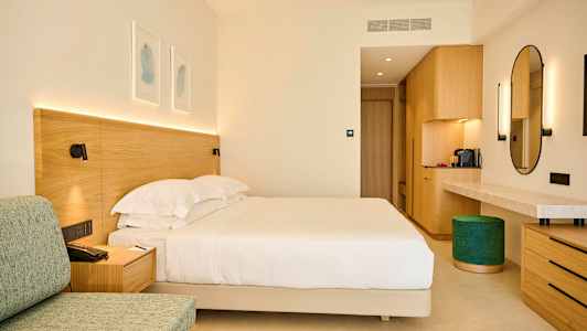 Et hotellrom med en stor seng, tremøbler og en stilfull moderne innredning. (AI-generert tekst)