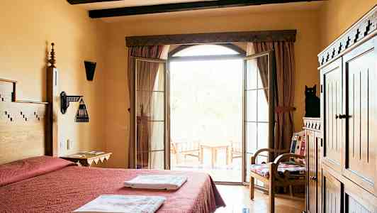 Et hotellrom med dobbeltseng, håndklær, treinnredning og en balkong med utsikt. (AI-generert tekst)