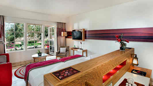 Hotellrom med moderne innredning og store vinduer mot hagen. (AI-generert tekst)