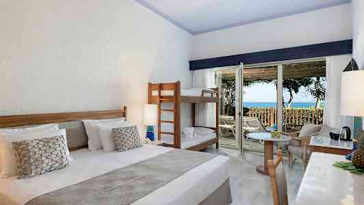 Hotellrom med dobbeltseng, køyeseng og tilgang til terrasse med havutsikt. (AI-generert tekst)