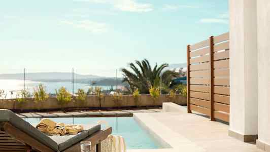 Solstol ved et basseng med utsikt mot havet. (AI-generert tekst)