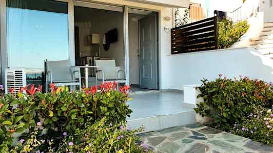 Uteplass med to stoler og bord foran en dør og glassparti. (AI-generert tekst)