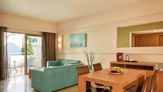 Et moderne innredet stue med en sofa, spisebord og stoler. En dør fører til en balkong. (AI-generert tekst)