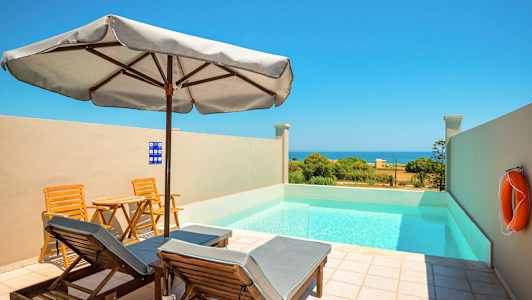 Et lite basseng med solsenger og parasoll utendørs, utsikt mot havet. (AI-generert tekst)