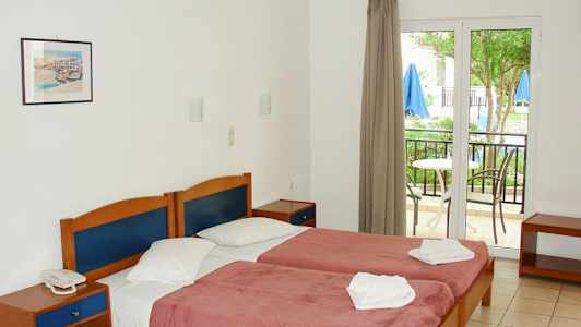 Dobbeltrom med senger, nattbord og balkong ute. (AI-generert tekst)