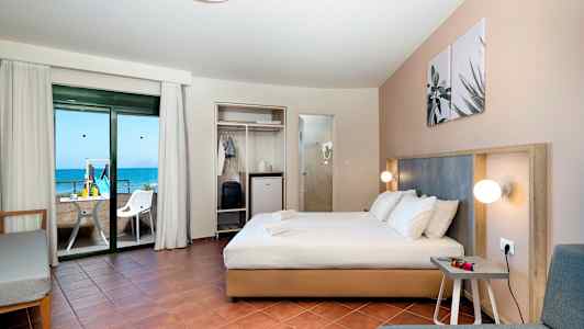 Hotellrom med dobbeltseng, sittegruppe og balkong med havutsikt. (AI-generert tekst)