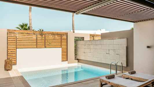 Privat bassengområde med solsenger og tregjerde. (AI-generert tekst)