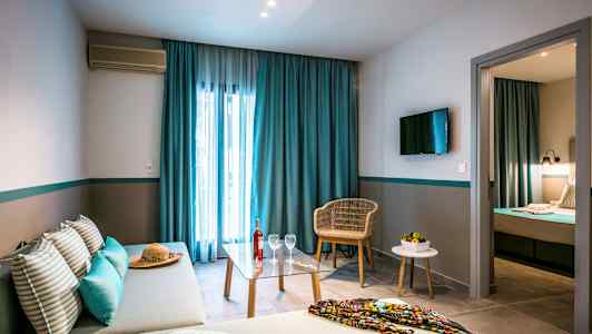 Bilde av et hotellrom med sofa, bord og stol, samt seng i et separat soverom. (AI-generert tekst)