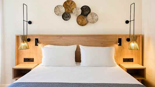 Seng med to puter og dekorasjoner på veggen. (AI-generert tekst)