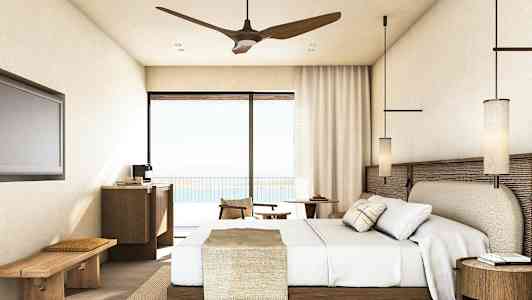 Et hotellrom med en seng, møbler og balkongdør med utsikt. (AI-generert tekst)