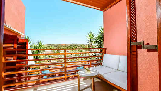 Uteområde med sitteplass og bord mot solfylt utsikt. (AI-generert tekst)