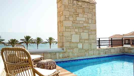 Terrasse med basseng, solsenger og utsikt over havet. (AI-generert tekst)