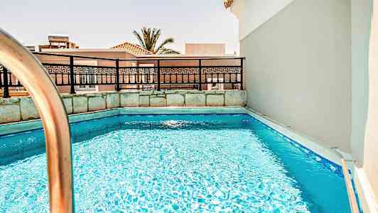 Bilde av et lite basseng med rekkverk og bygninger i bakgrunnen. (AI-generert tekst)