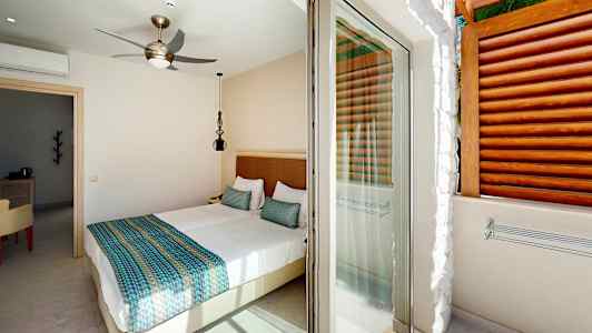 Et lyst soverom med en dobbeltseng og tilgang til en terrasse. (AI-generert tekst)