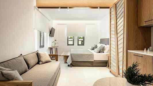 Moderne innredet hotellsuite med sittemøbler, seng og kjøkkenområde. (AI-generert tekst)