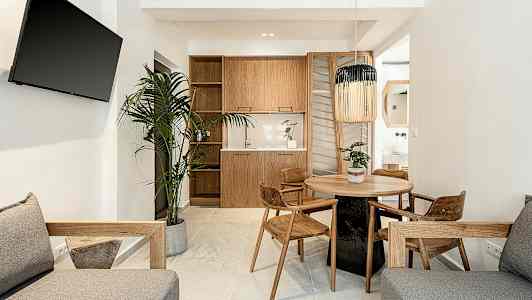 Moderne stue med tremøbler, et rundt spisebord og en plante. (AI-generert tekst)