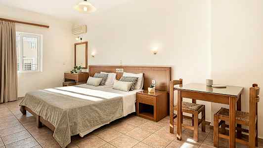 Et hotellrom med dobbeltseng og tremøbler. (AI-generert tekst)