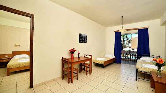 Et hotellrom med tre senger, spisebord og stor vindusutgang. (AI-generert tekst)