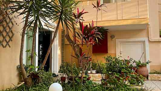 Utsiden av et hus med en frodig hage foran. (AI-generert tekst)