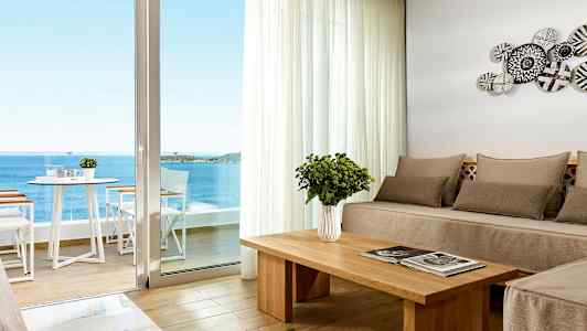 Moderne innredet rom med havutsikt gjennom en stor vindusdør. (AI-generert tekst)