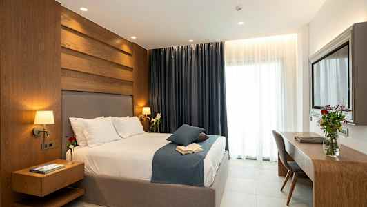 Et moderne soverom med en stor seng, trepanel, mørke gardiner og et skrivebord med en blomsterpotte. (AI-generert tekst)