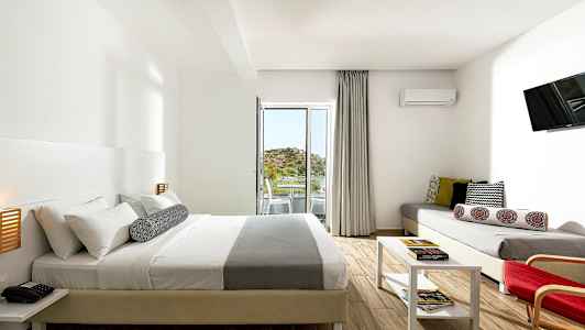 Et moderne hotellrom med dobbeltseng, sofa, bord og balkong med utsikt. (AI-generert tekst)