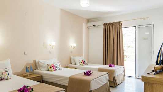 Hotellrom med tre enkeltsenger, dekorert med blomster. (AI-generert tekst)