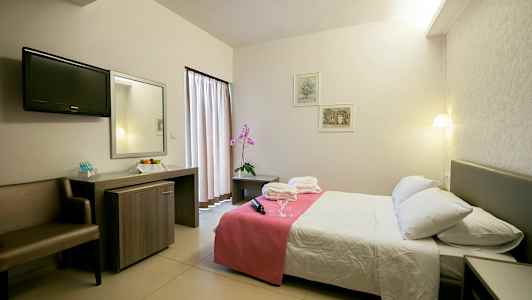 Hotellrom med dobbeltseng, nattbord og skrivebord. (AI-generert tekst)