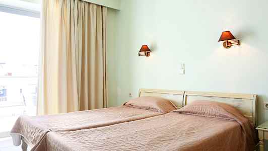 To enkeltsenger med rosa sengetepper i et rom med vindusåpning og vegglamper. (AI-generert tekst)